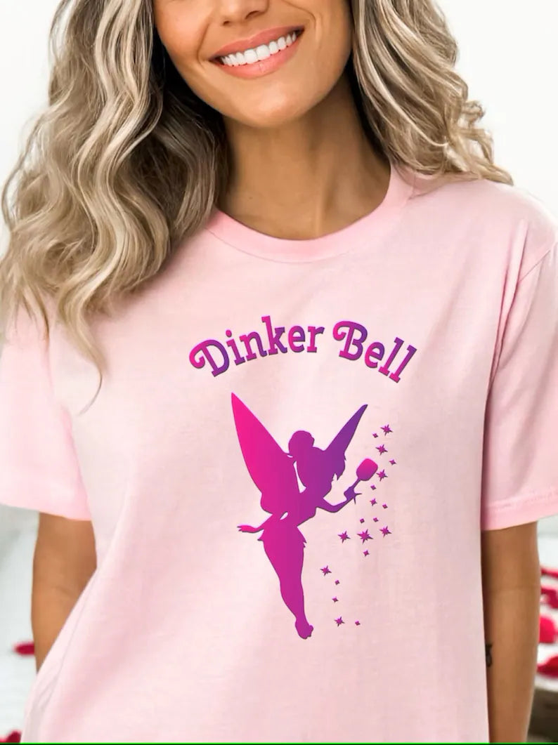Super super cute pickleball t-shirt that says Dinker Bell with Tinker Bell holding a pickleball paddle.